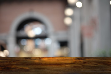Empty dark wooden table in front of abstract blurred bokeh background of restaurant . can be used for display or montage your products.Mock up for space.