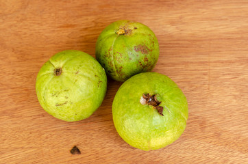 Three Round Apple Guava On Wooden Table