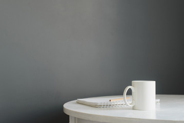 white ceramic coffee cup with diary, pencil on wooden table in scandinavian kitchen interior, horizontal stock photo image with copy space for text