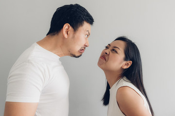 Angry couple lover in white t-shirt and grey background.
