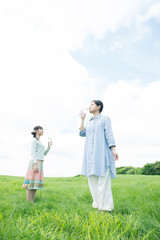 草原で水を飲む2人の女性