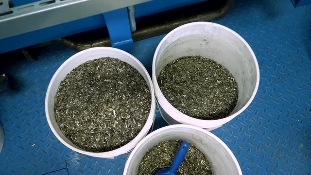 Three buckets of metal shavings in a metal recycling plant