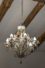 A chandelier hanging from a roof beam image with copy space in portrait format