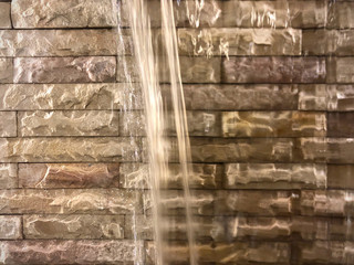 beautiful waterfall background on rock tile wall decorated by rock tiles beige color separate to two layer, brown background  separate to two part, interior design by water and tile background texture