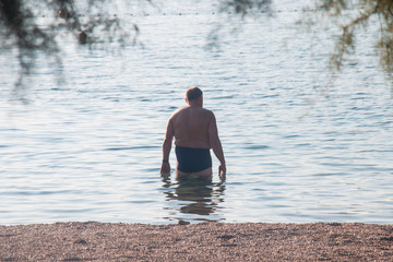 male pensioner in the water swim in the morning