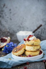 Cheesecakes for Breakfast decorated with pumpkin seeds and pomegranate seeds. Selective focus.