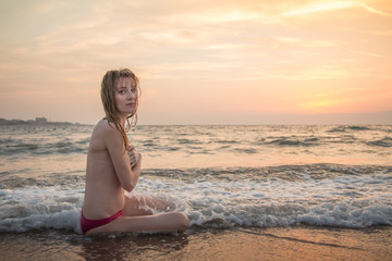 Girl rests and has fun in sea wave at sunset