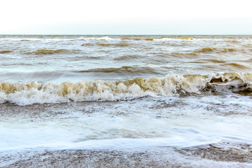 Waves on the shore. Sea wave close up on a sandy beach with sunlight.