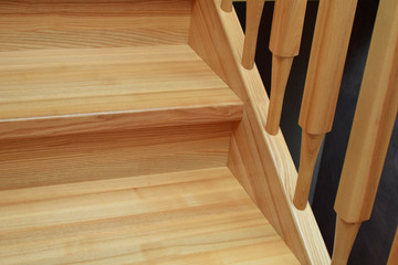 Part of natural ash tree wooden stairs steps with railings.