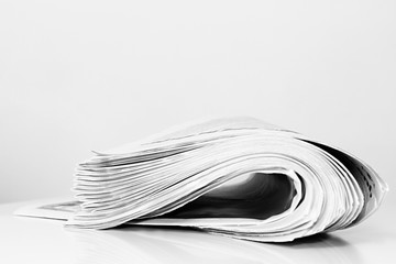 newspaper rolled up and sitting on a table