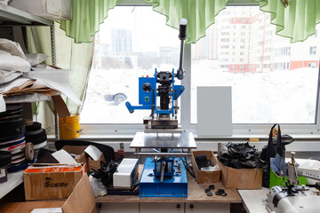 Press machine in the workshop for doing the embossed logo and letters on the leather product that heats the cliche and squeezes the desired image on the material