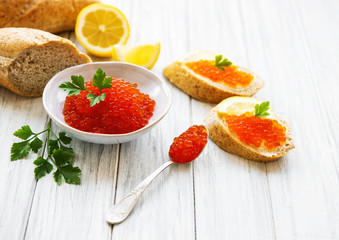 Fototapeta na wymiar Red caviar in bowl and sandwiches