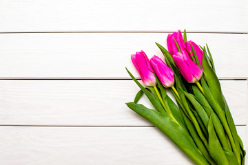 Fototapeta premium Bouquet of pink tulips on white wooden background