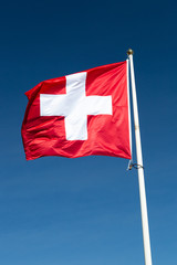 The Flag of Switzerland with a blue sky