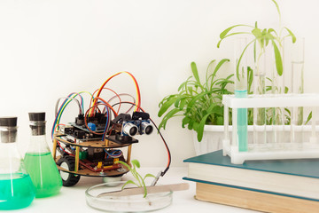 Robot handmade in the laboratory. Here are the plants, test tubes, microscope all around. STEM and STEAM education. An experiment in biology, robotics, chemistry, physics and mathematics.