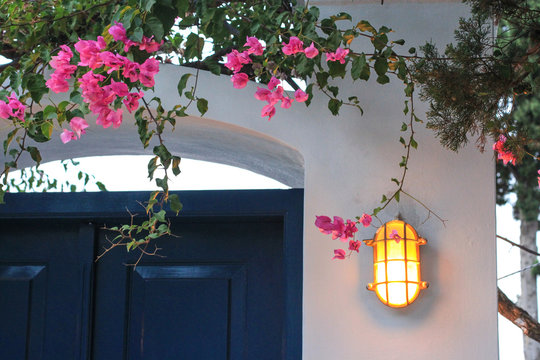 Lighting lantern on the white wall and blue door, typical entrance to greek house, Spetses town, Spetses island, Greece
