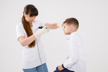 Obraz premium Famale doctor checking nose of a male patient with the medical stick. Doctor checking a patients nose.