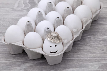 Eggs with a smile on a gray wooden table.