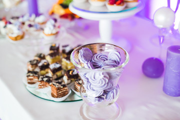 Delicious sweets on wedding candy buffet with desserts, cupcakes