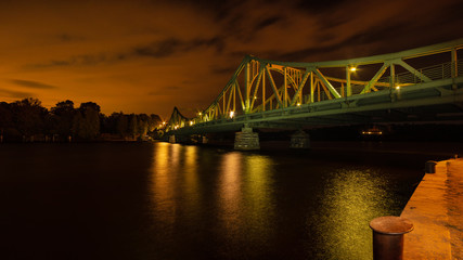 The Glienicker bridge over the Havel between Potsdam and Berlin at night mystically illuminated