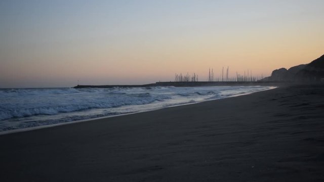 Waves crashing on the beach at sunset