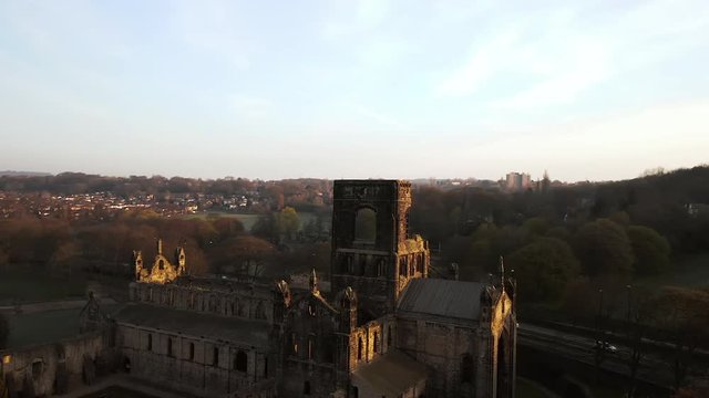 Aerial Tracking Shot of Kirkstall Abbey at Dawn on Sunny Spring Day side on with Sun