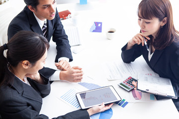 タブレットを見ながら事業計画を練る経営陣