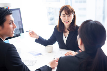 資料を見ながら企画を練るマネージャーたち