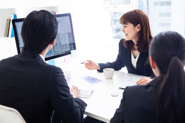 資料を見ながら企画を練るマネージャーたち