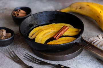 Fried bananas in frying pan. Cinnamon dusted plantains pan fried in butter is a popular dessert in Mexico and other South Latin American countries. © vasanty