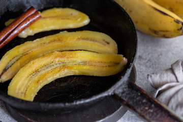 Fried bananas in frying pan. Cinnamon dusted plantains pan fried in butter is a popular dessert in Mexico and other South Latin American countries. © vasanty