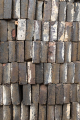A pile of gray bricks ready for use, looking at the long edge of the bricks
