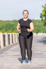 over size woman while jogging in the early morning in the park