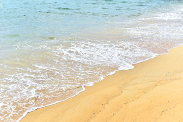 Fototapeta na wymiar Soft waves of blue ocean on sandy beach