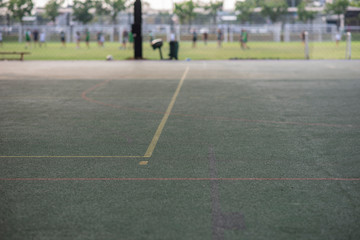 Rubber floor special used for indoor gym only, seeing with yellow lines for volleyball  court and orange for basketball court. Seeing faraway is outdoor field with rugby touch drilling.