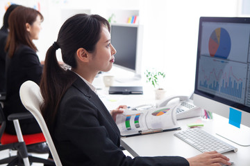 グラフつきの資料を作成している女性社員