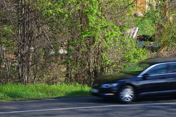 european cars passing by with green landscape in the background