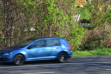 european cars passing by with green landscape in the background