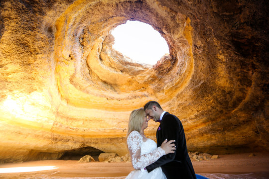 Beautiful wedding couple posing in the caves of Benagil