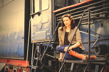 beautiful woman near an old steam locomotive