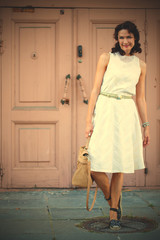 smiling dark-haired middle-aged woman dressed in a light summer dress