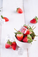 Fresh strawberries in a bowl on wooden table