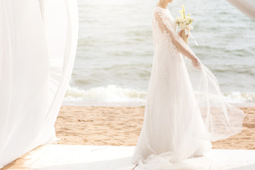 Plakat happy bride with boquet on the beach.