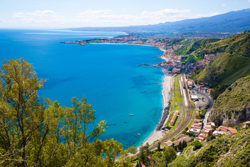 Sicily, Italy. Beautiful panoramic view to Etna volcano and Mediterranean sea (Ionian sea). Bright turquoise waters on summer sunny day. 