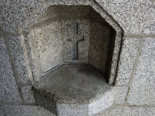 Holy water font cemented up for hygiene reasons as holy water is now dispensed using water tank dispensers to avoid spreading germs.