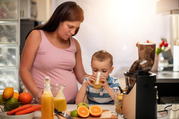 Family make fresh orange juice in their kitchen