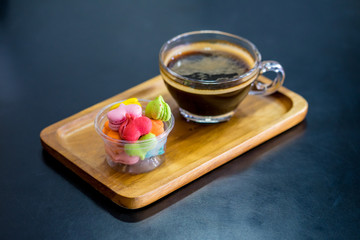 stack of macaron heart shape dessert with coffee cup on woodent plate