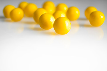 yellow round pills vitamins bada on white table close up