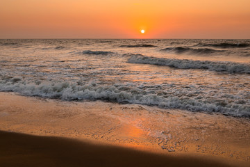 Fototapeta na wymiar Sea waves on the background of the setting sun. Vacation at sea.