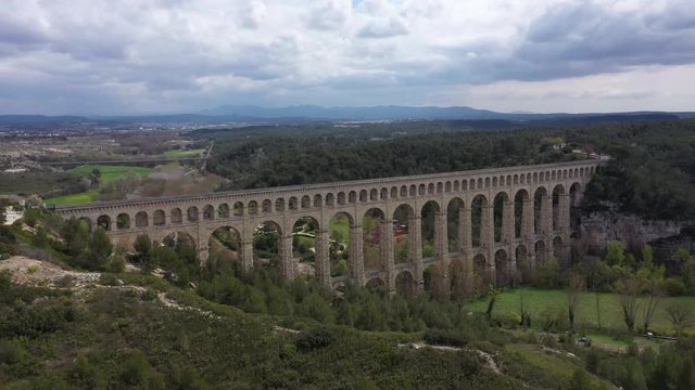 Back aerial traveling over the largest stone aqueduct in the world Roquefavour cloudy day
